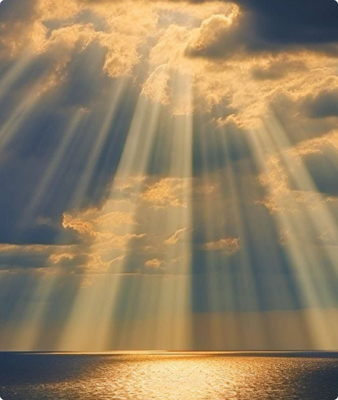 Sunlight streaming through clouds over the sea